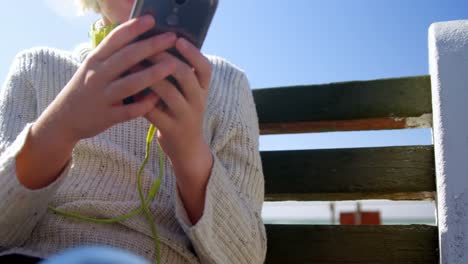 Teenage-girl-using-mobile-phone-at-beach-4k