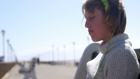 Girl-listening-music-on-headphones-at-beach-4k