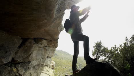 Excursionista-Masculino-Tomando-Fotos-Con-Un-Teléfono-Móvil-Cerca-De-Una-Cueva-4k