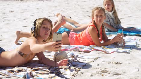 Siblings-taking-selfie-with-mobile-phone-in-beach-4k
