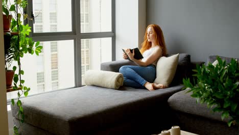 Woman-reading-a-book-in-living-room-4k