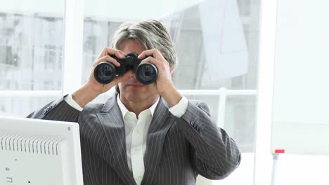 Competitive-male-executive-looking-through-binoculars