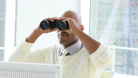 Ethnic-businessman-looking-through-binoculars