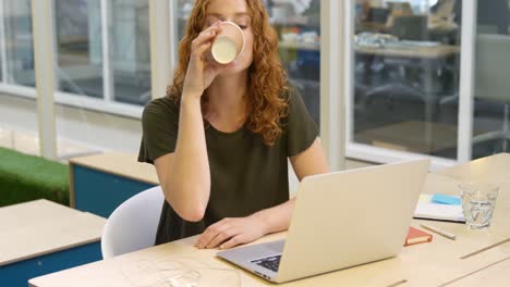 Mujer-De-Negocios-Usando-Laptop-Mientras-Toma-Café-4k