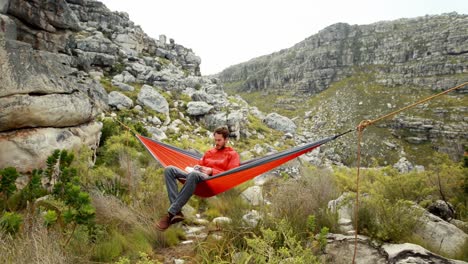 Male-hiker-reading-a-book-relaxing-in-hammock-4k