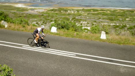 Female-cyclist-cycling-on-a-coastal-road-4k-
