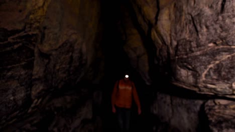 Male-hiker-exploring-a-dark-cave-4k