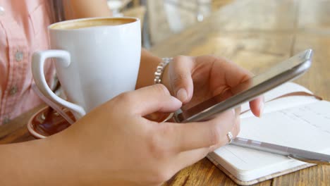 Teenage-girl-using-mobile-phone-in-restaurant-4k