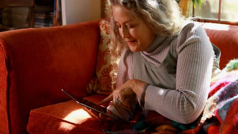 Mujer-Madura-Usando-Tableta-Digital-En-La-Sala-De-Estar-4k