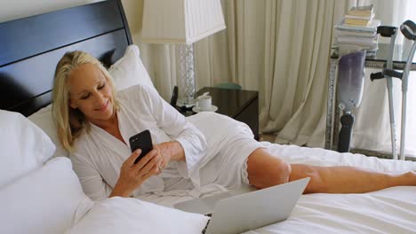 Disabled-woman-using-mobile-phone-in-bedroom-4k