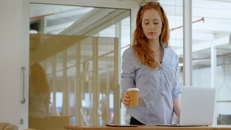 Weibliche-Führungskraft-Trinkt-Kaffee,-Während-Sie-Im-Büro-4K-Einen-Laptop-Benutzt