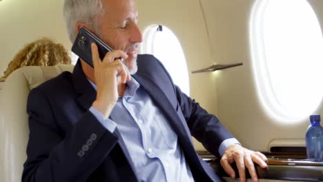 Businessman-talking-on-mobile-phone-in-private-jet-4k