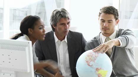 United-business-people-looking-at-a-terrestrial-globe
