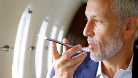 Businessman-talking-on-mobile-phone-while-travelling-in-private-jet-4k