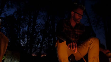 Man-sitting-near-campfire-in-the-forest-4k