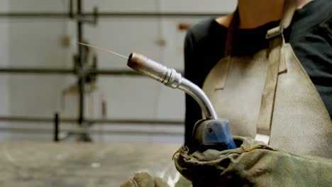 Female-welder-holding-blowing-torch-in-workshop-4k
