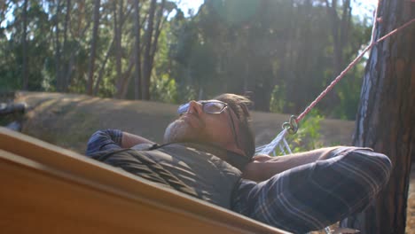 Man-relaxing-in-a-hammock-on-a-sunny-day-4k