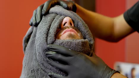 Man-getting-face-massage-at-hair-salon-4k