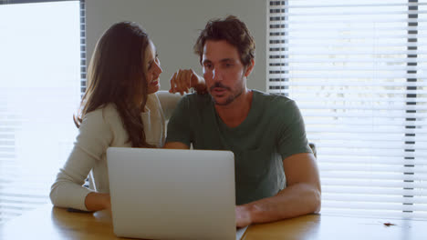 Couple-using-laptop-at-home-4k