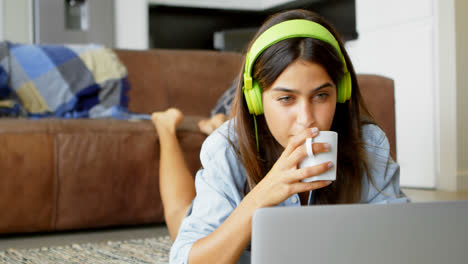 Woman-using-laptop-while-having-tea-4k