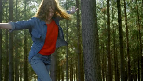 Woman-walking-on-wooden-log-in-the-forest-4k