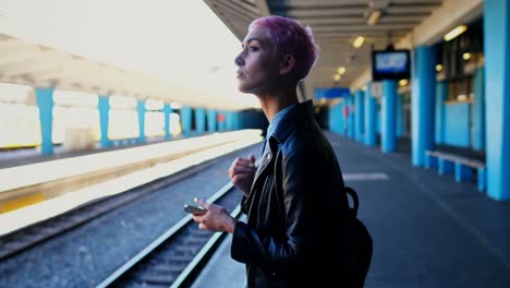 Woman-using-mobile-phone-while-waiting-for-train-4k