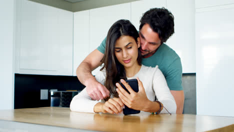 Man-kissing-woman-while-using-mobile-phone-4k