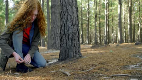 Woman-tying-shoe-laces-in-the-forest-4k