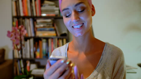 Pink-hair-woman-using-mobile-phone-at-home-4k