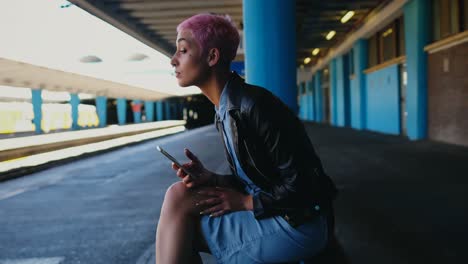 Woman-using-mobile-phone-while-waiting-for-train-at-platform-4k