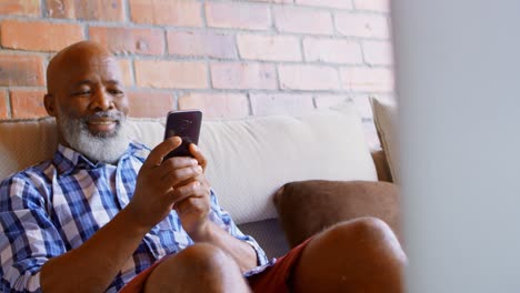 Senior-man-using-mobile-phone-in-living-room-4k