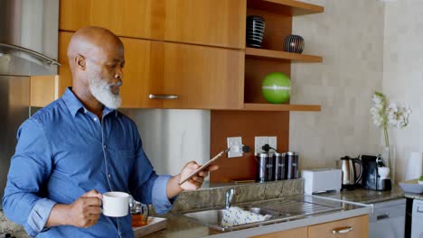 Älterer-Mann-Nutzt-Digitales-Tablet,-Während-Er-Schwarzen-Kaffee-In-Der-Küche-4k-Trinkt