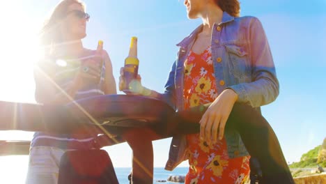 Male-and-female-friends-toasting-beer-bottles-in-the-car-4k