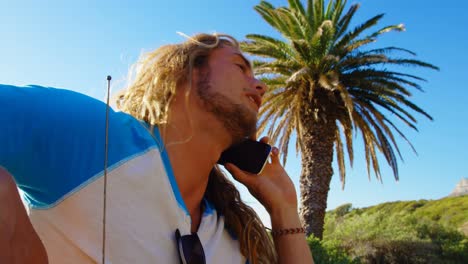 Man-talking-on-mobile-phone-in-the-beach-4k