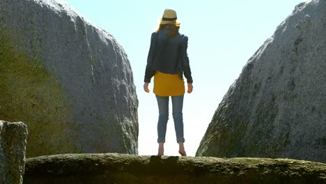 Woman-standing-on-a-rock-at-beach-4k