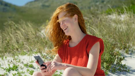 Woman-using-mobile-phone-in-the-beach-on-a-sunny-day-4k