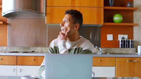 Hombre-Usando-Laptop-En-La-Cocina-De-Casa-4k