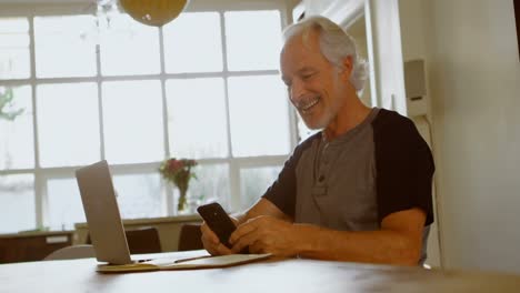 Senior-man-using-mobile-phone-at-home-4k