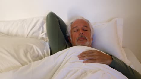 Senior-man-sleeping-on-bed-in-bedroom-4k