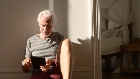 Älterer-Mann-Nutzt-Digitales-Tablet-Auf-Dem-Boden-Zu-Hause-4k