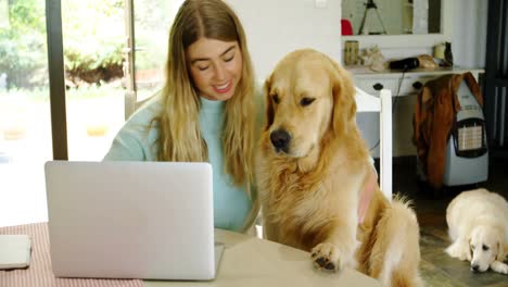 Woman-using-laptop-with-her-dog-at-home-4k