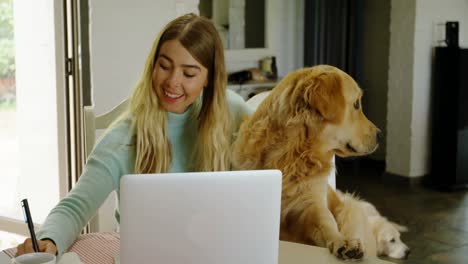 Woman-writing-on-notepad-with-her-dog-at-home-4k