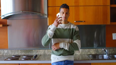 Man-talking-on-mobile-phone-in-kitchen-4k