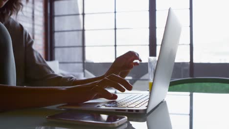 Woman-having-juice-while-using-laptop-at-home-4k