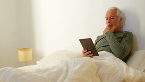 Älterer-Mann-Benutzt-Digitales-Tablet-Auf-Dem-Bett-Im-Schlafzimmer-4K