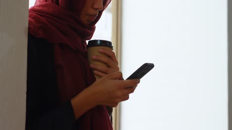 Weibliche-Führungskraft-Trinkt-Kaffee,-Während-Sie-Ihr-Mobiltelefon-In-4K-Nutzt