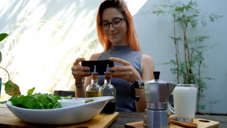 Young-woman-photographing-salad-on-the-table-in-restaurant-4k