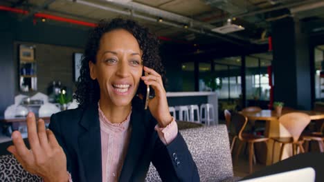 Businesswoman-talking-on-mobile-phone-in-office-cafeteria-4k