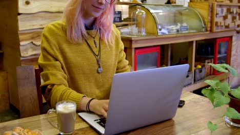 Young-woman-using-laptop-in-cafe-4k