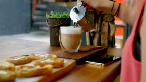 Woman-pouring-coffee-in-the-cup-at-cafe-4k